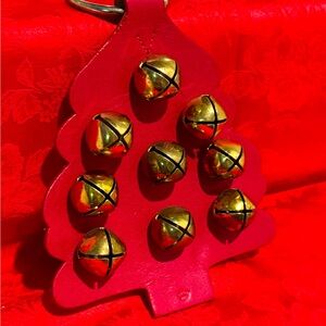 Christmas door knocker with 9 brass bells on tree shape of red leather.